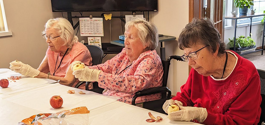 Meadows ladies peel apples to make apple crisp.